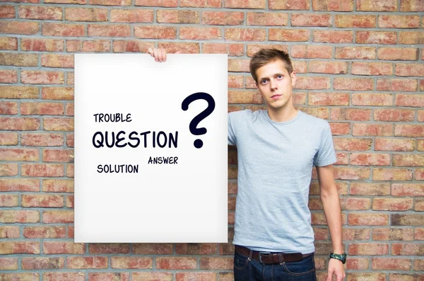 Young man holding whiteboard with question and solution words — Stock Photo, Image