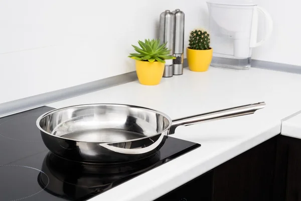 Frying pan in modern kitchen with induction stove — Stock Photo, Image