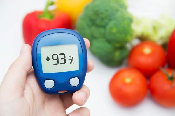 . Diabetes doing glucose level test. Vegetables in background Royalty Free Stock Photos