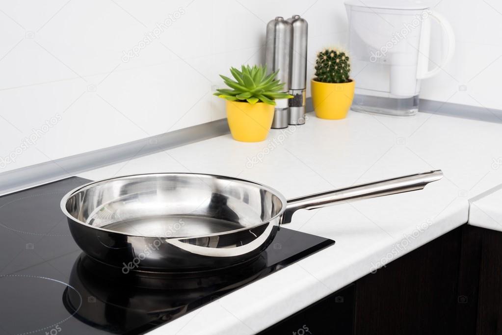 Frying pan in modern kitchen with induction stove