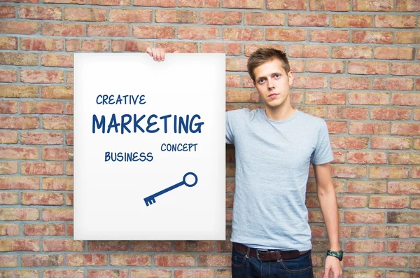 Young man holding whiteboard with marketing content. Business pr — Stock Photo, Image