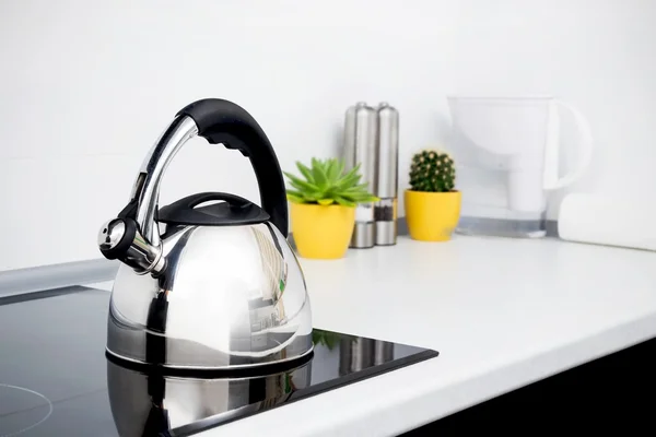 Steel kettle in modern kitchen with induction stove — Stock Photo, Image