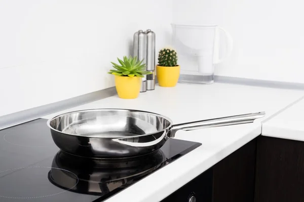 Frying pan in modern kitchen with induction stove — Stock Photo, Image