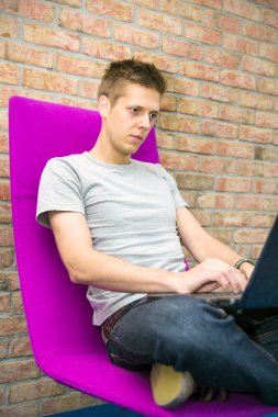 adam sandalyede oturan ve laptop ile çalışma