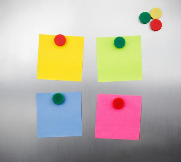 Notas coloridas e ímãs na geladeira metálica inox — Fotografia de Stock