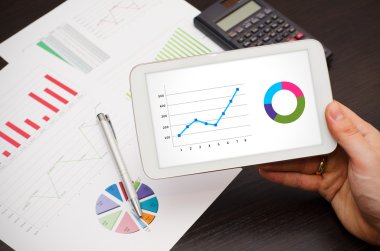 tablet pc ile çalışan bir iş adamı. rapor arka plan grafikleri
