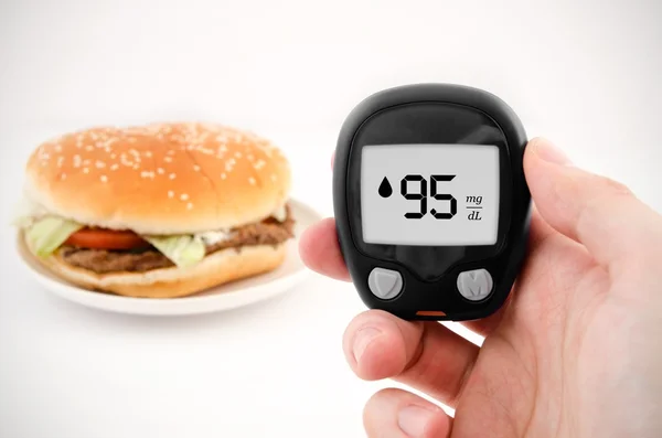 Hand holding meter. diabetes bloedglucose niveau test doen. Hamburger — Stockfoto