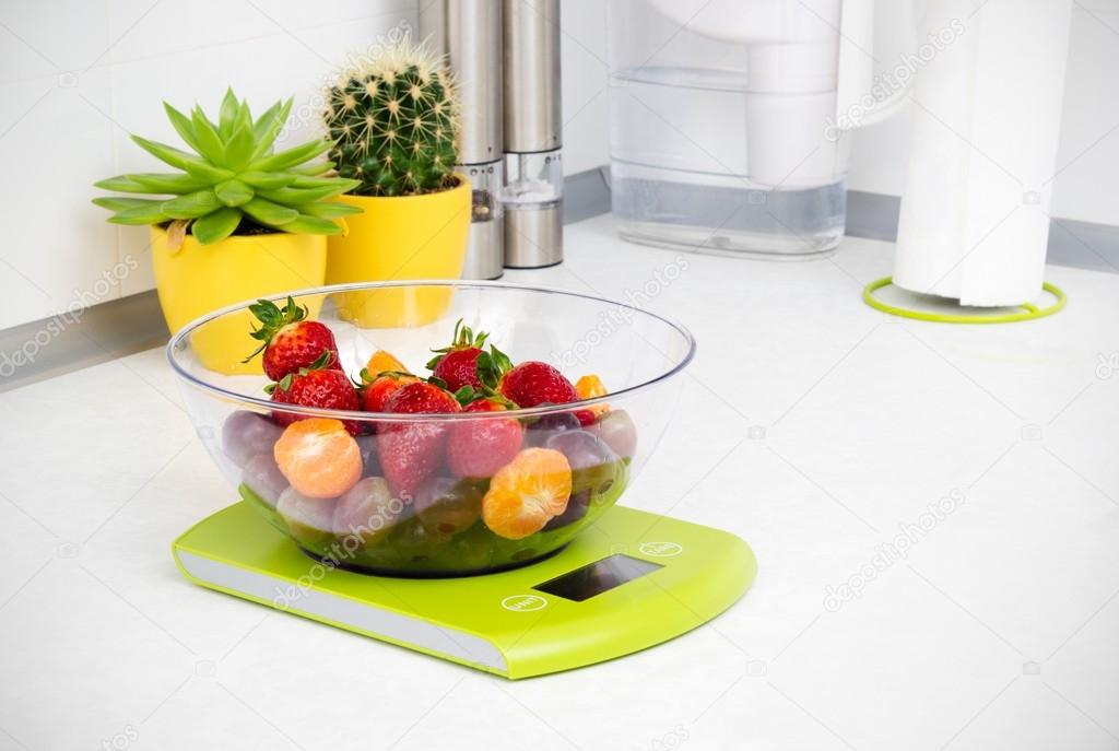 Lots of fruit on the kitchen scale in a modern kitchen