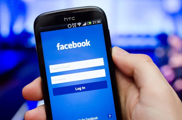 ヴロツワフ, ポーランド - 2014 年 4 月 13 日: facebook のソーシャル ネットワークのモバイル アプリでスマート フォンを持っている手 — ストック写真