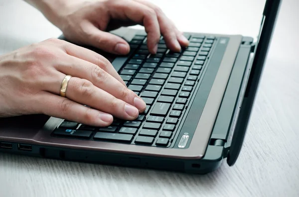 Homem trabalhando com laptop em fundo de madeira — Fotografia de Stock