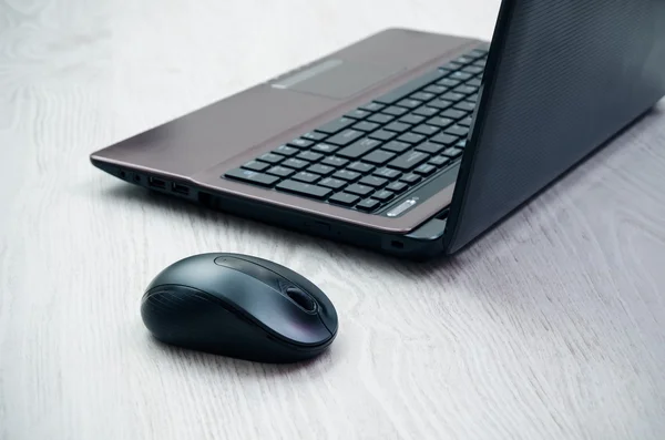 Laptop moderno e mouse na mesa de madeira leve — Fotografia de Stock