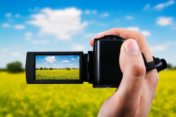 Videokamera oder Camcorder zeichnen gelbes Feld und blauen Himmel auf — Stockfoto