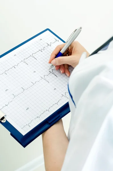 Doctor with clipboard describes graph — Stock Photo, Image