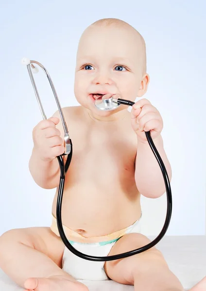 Baby mit Stethoskop auf blauem Hintergrund — Stockfoto