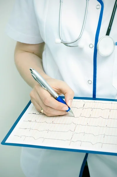 Doctor with clipboard describes graph — Stock Photo, Image