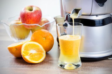 Juicer and orange juice. Fruits in background clipart