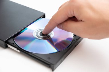 Harici DVD okuyucu, adam diski yerleştiriyor. Veri güvenliği, dijital veri depolama