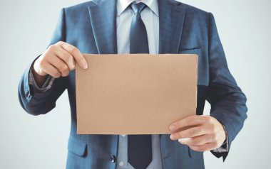 Elinde boş karton tabak tutan bir iş adamı. Tur metnini yerleştir