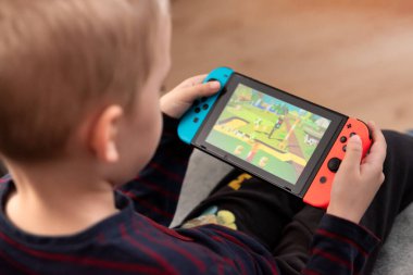 Wroclaw, Polonya - 27 Ocak 2022: Çocuk Nintendo Switch konsolu oynuyor. Nintendo Anahtarı popüler mobil konsoldur.