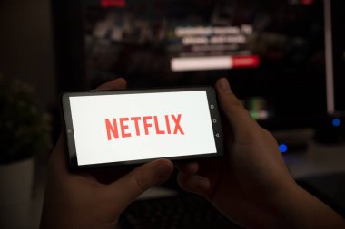 Wroclaw, Polonya - 27 Ocak 2022: Ekranda Netflix logosu olan adam. Netflix en popüler video yayın platformudur.