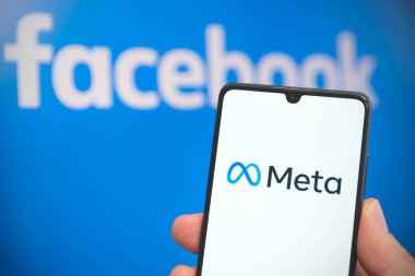 Wroclaw, Polonya - APR 01, 2022: Facebook şirket adını Meta olarak değiştirir. Akıllı telefondaki meta ve arka plandaki Facebook logosu