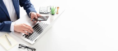 Ofiste çalışan bir iş adamı. Bilgisayar ve akıllı telefonla çalışan muhasebeci ya da muhasebeci.