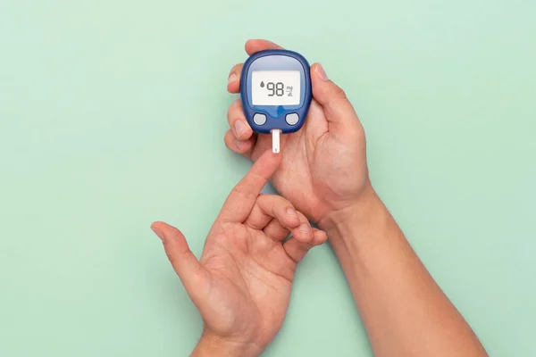 Человек Глюкометром Проверяет Уровень Сахара Крови Концепция Диабета Зеленом Фоне — стоковое фото