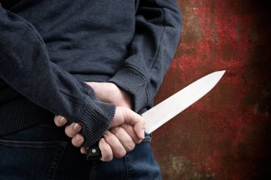 Silhouette criminal holding knife on dirty background