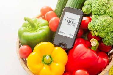 Glucometer with fresh vegetables. Healthy food, diet and nutrition