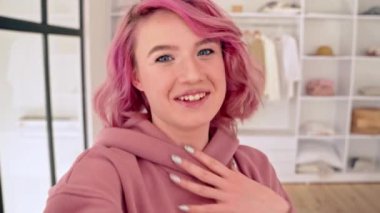 Pembe saçlı sosyal medya blogcusu, elbise dolabının önünde video klip dersi kaydediyor..