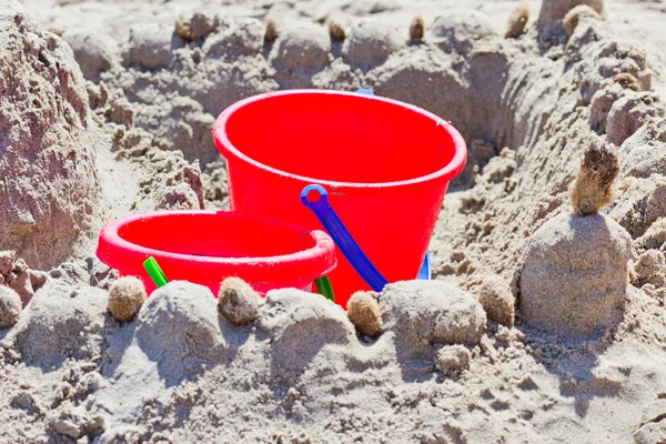 Seau rouge dans le sable — Photo