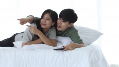 Mutlu Asyalı lezbiyen çift aktivitesi konsepti, yaşlı gözlüklü kadın genç kadının yatakta soru sorduğunu gösteriyor