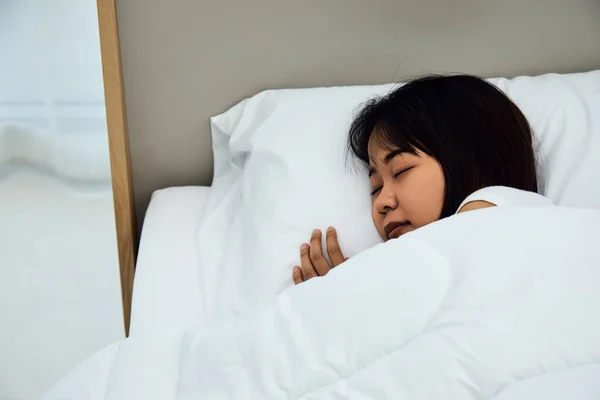 Close up Asian woman sleeping on white bed in the bedroom with sweet dreams and enjoys good rest at home