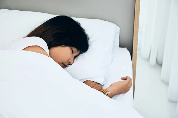 Close up Asian woman sleeping on white bed in the bedroom with sweet dreams and enjoys good rest at home