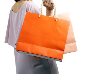 Güzel bir kadının portresi günlük kıyafetler giyiyor ve beyaz arka planda izole edilmiş renkli alışveriş çantaları tutuyor.