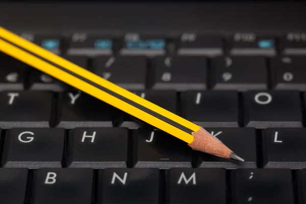 Черная клавиатура и карандаш — стоковое фото