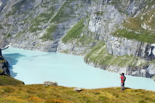 Фотограф и озеро в швейцарских Альпах — стоковое фото