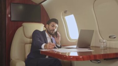 İş adamı özel jette telefonla konuşuyor..