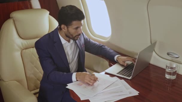 Affärsman Som Arbetar Med Pappersdokument Och Laptop Medan Flyger Jetplanet — Stockvideo
