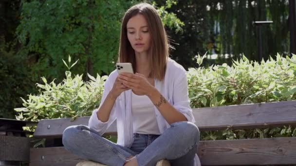 若い女性は携帯電話で悪い知らせを読んでいる 動揺と負の感情 スローモーション — ストック動画