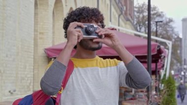 Sırt çantalı turist dışarıda fotoğraf çekiyor..