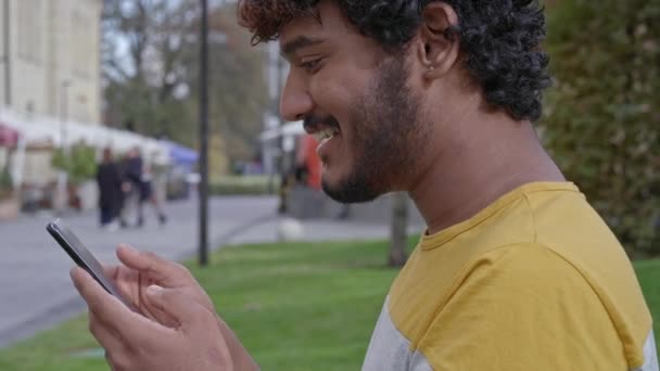 Detail Portrét Usmívajícího Mladého Muže Držícího Používajícího Mobilní Telefon — Stock video