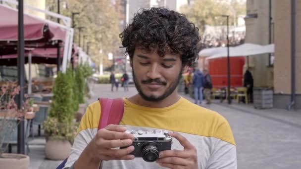 Щасливий Хлопець Фотоапаратом Фотографує Вулиці Дивлячись Камеру Посміхаючись — стокове відео