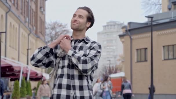 Щасливий Чоловік Рюкзаком Йде Вулиці Посміхаючись Дивлячись Навколо Камеру Сповільнення — стокове відео