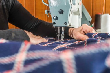 Kadın dikiş makinesine dikiş dikiyor, yüzü yok.