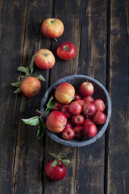 Tahta arka plandaki kasede taze kırmızı elmalar, üst manzara. Sonbahar hasat konsepti