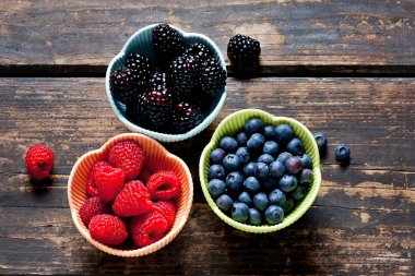 Masadaki kaselerde ahududu, böğürtlen ve yabanmersini var.