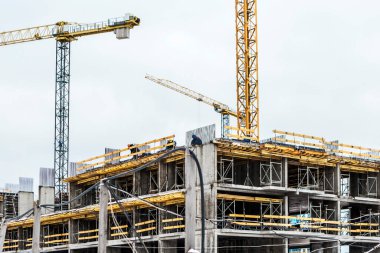 Gökyüzüne karşı kule vinçleri olan bir inşaat sahası