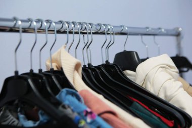 Giysiler tasarımcı giyim mağazasının rafında asılı.
