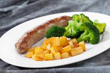 Kızarmış patates ve brokoli ile ızgara sosis.